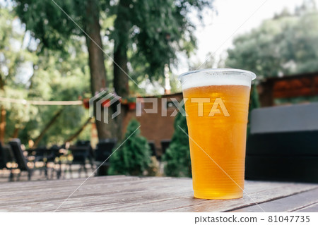 Light beer in glass on wooden table. 81047735
