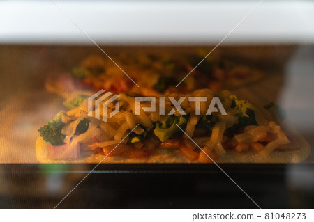 一張美味的手工比薩的照片。烹飪。在烤箱裡烤。 一張美味的手工比薩的照片。烹飪。在烤箱裡烤。 81048273