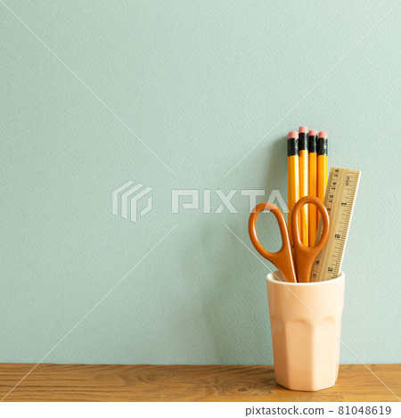 Pencils, ruler and scissors in holder on wooden desk. blue wall background. workspace Pencils, ruler and scissors in holder on wooden desk. blue wall background. workspace 81048619