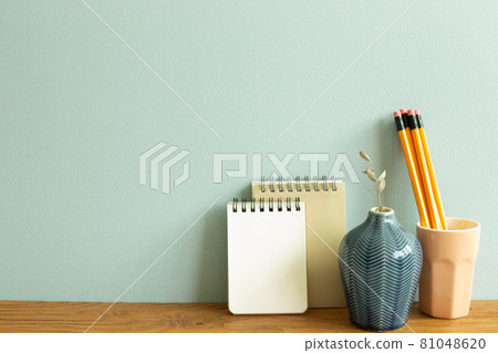 Notebook, pencil, eucalyptus on wooden desk. blue wall background. workspace Notebook, pencil, eucalyptus on wooden desk. blue wall background. workspace 81048620