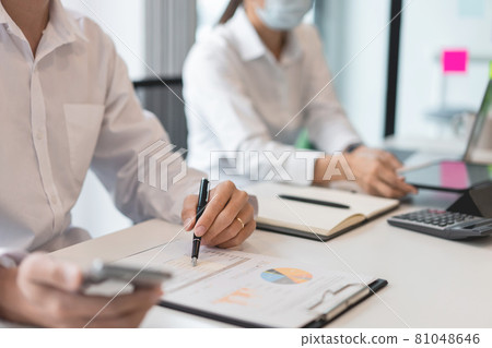Freelancers wearing protective masks keeping distance as preventive action when working together 81048646