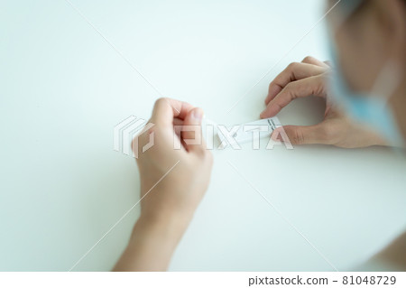 Asian woman using COVID-19 antigen test. Asian woman using COVID-19 antigen test. 81048729