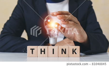 Businessman touch Light bulb on wooden cube blocks with word think. Businessman touch Light bulb on wooden cube blocks with word think. 81048845