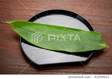 Half-moon tray with bamboo grass for the background of cooking, food, etc. Half-moon tray with bamboo grass for the background of cooking, food, etc. 81049922