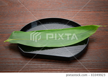 Half-moon tray with bamboo grass for the background of cooking, food, etc. 81049923