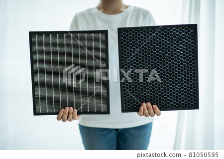 Woman holding an air purifier filters.  Woman holding an air purifier filters.  81050595