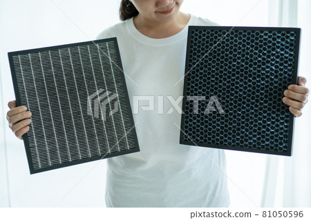 Woman holding an air purifier filters.  Woman holding an air purifier filters.  81050596