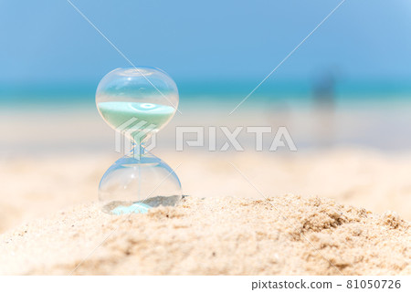 Hourglass summer and vacations time on a beach in the sand with blue sky and copy space. Hourglass summer and vacations time on a beach in the sand with blue sky and copy space. 81050726