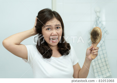 Woman concerning about hair fall problem. 81051068