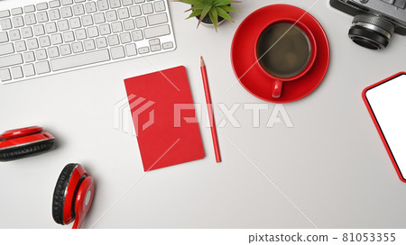 Smart phone, coffee cup, headphone and camera on white office desk. 81053355