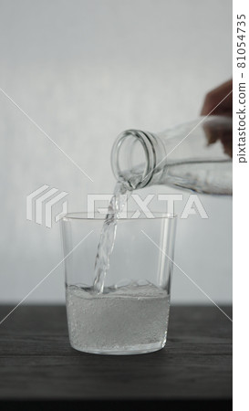 Vertical shot of making espresso tonic in tumbler glass, pour tonic 81054735