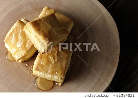 Honey on the hot biscuits on a log-shaped cutting board. Honey on the hot biscuits on a log-shaped cutting board. 81054821
