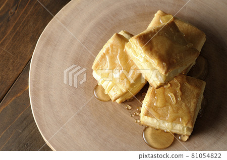 Honey on the hot biscuits on a log-shaped cutting board. Honey on the hot biscuits on a log-shaped cutting board. 81054822