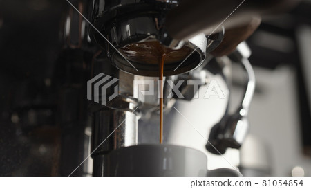 Low angle of pulling espresso shot with naked portafilter 81054854