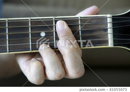 Hand holding guitar chords 81055073