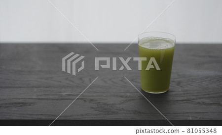 Matcha drink into tumbler glass on black oak table 81055348
