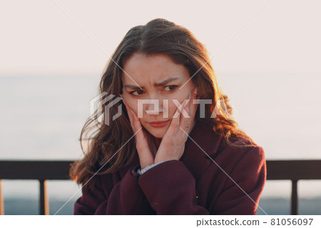 Young smiling brunette woman in coat outdoors portrait Young smiling brunette woman in coat outdoors portrait 81056097