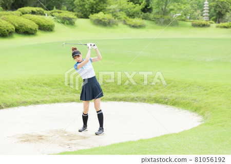 Female bunker shot enjoying golf 81056192