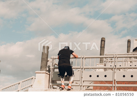 Young sporty guy doing parkour at the city street. 81056550
