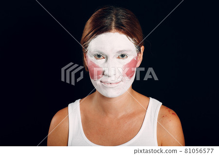 Young woman applying make-up, paints face with painting brush and makeup. How not to do make up concept Young woman applying make-up, paints face with painting brush and makeup. How not to do make up concept 81056577