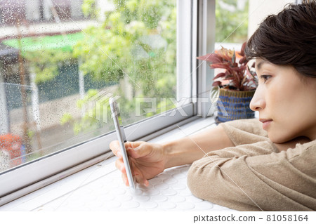 A woman who cannot go out due to rain 81058164
