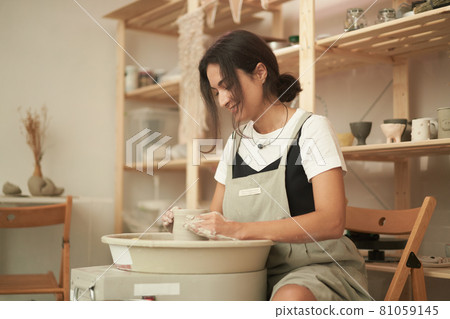 Young woman crafting pottery in workshop Young woman crafting pottery in workshop 81059145