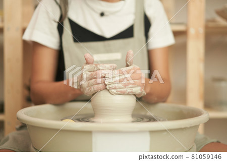 Craftswoman creating clay pot in workshop Craftswoman creating clay pot in workshop 81059146