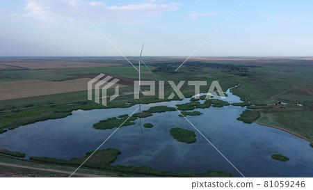 Wind turbine on the shore of the lake. Evening time. Wind turbine on the shore of the lake. Evening time. 81059246