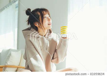 A woman listening to music in a room 81059634