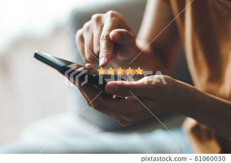 Close up of woman customer giving a five star rating on smartphone. Review, Service rating, satisfaction, Customer service experience and satisfaction survey concept. 81060030