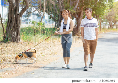 People couple walking with friendly pet beagle dog modern family morning activity for healthy. 81060865