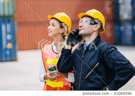 logistic worker teamwork working using smartphone calling command order control loading containers at port cargo to trucks for export and import goods. logistic worker teamwork working using smartphone calling command order control loading containers at port cargo to trucks for export and import goods. 81060896