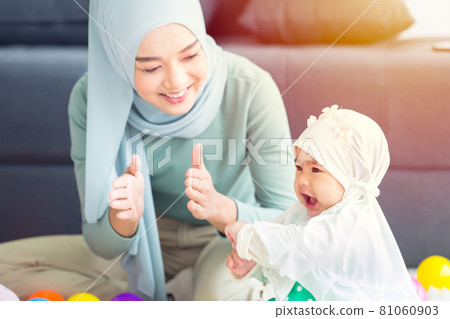 Muslim Mother happy smile enjoy playing with her baby  infant care happy together lovely home. 81060903