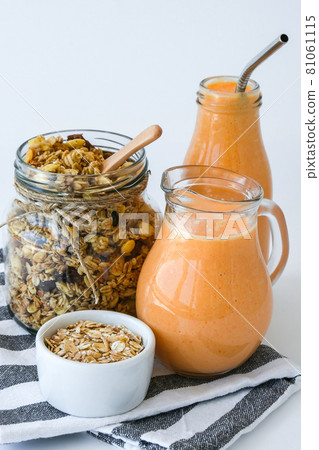 Seasonal pumpkin carrot smoothie drink detox with eco metal drinking straw Glass jar granola muesli oatmeal breakfast. Orange smoothie. Clean eating, weight loss, healthy dieting food concept Seasonal pumpkin carrot smoothie drink detox with eco metal drinking straw Glass jar granola muesli oatmeal breakfast. Orange smoothie. Clean eating, weight loss, healthy dieting food concept 81061115
