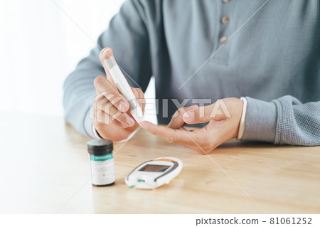 Man using lancet on finger for checking blood sugar level by Glucose meter, Healthcare and Medical, diabetes, glycemia concept Man using lancet on finger for checking blood sugar level by Glucose meter, Healthcare and Medical, diabetes, glycemia concept 81061252