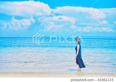 A woman standing on the beach 81062114