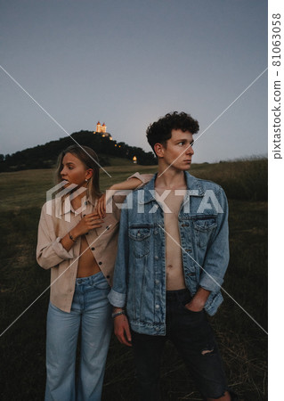 Young couple standing in nature in countryside, looking away from each other. Young couple standing in nature in countryside, looking away from each other. 81063058