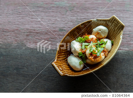 Thai style pork balls seasoning with spicy-sweet dipping sauce in ceramic bowl. It is a delicious appetizer. 81064364