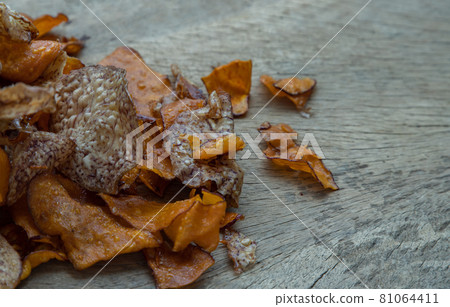 Mixed thai sweets made from sliced sweet potato coated with sugar (Potato chip) on rustic wooden background. Mixed thai sweets made from sliced sweet potato coated with sugar (Potato chip) on rustic wooden background. 81064411