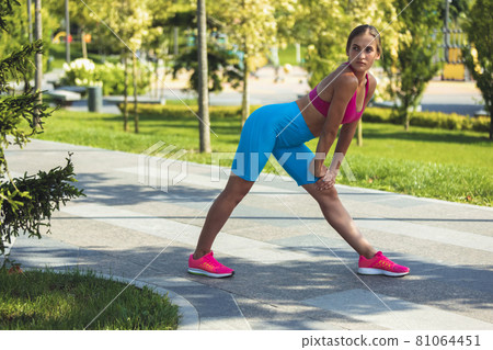 Young slim sportive caucasian woman working out, doing fitness, yoga in the park or on city street. Young slim sportive caucasian woman working out, doing fitness, yoga in the park or on city street. 81064451