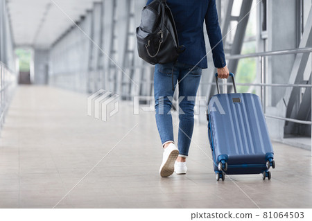 Rear View Of Unrecognizable Man Walking With Suitcase In Airport Terminal 81064503