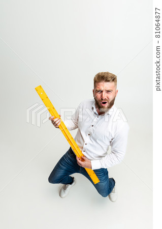 High angle view of funny bearded man, builder, designer or architect with professional equipment isolated on white studio background. High angle view of funny bearded man, builder, designer or architect with professional equipment isolated on white studio background. 81064877
