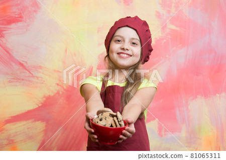 child, small girl in red chef hat, apron with chocolate cookies 81065311
