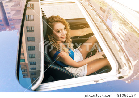 Top view from sunroof of a young beautiful woman sitting on car seat and drive carefuly. Top view from sunroof of a young beautiful woman sitting on car seat and drive carefuly. 81066157