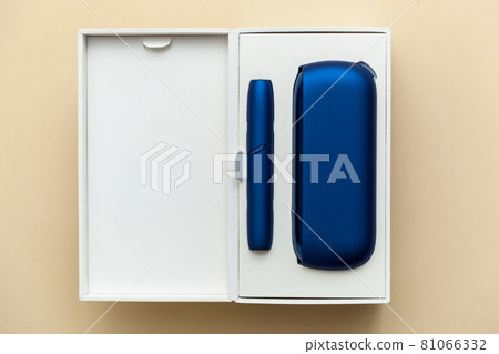 Iqos electronic blue cigarette on a beige background. Iqos electronic blue cigarette on a beige background. 81066332