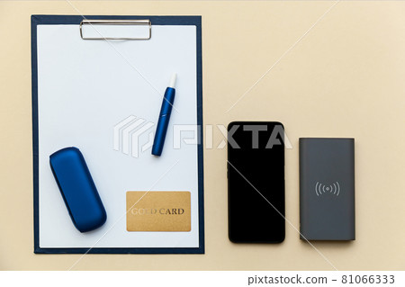 Iqos electronic blue cigarette on a beige background. Iqos electronic blue cigarette on a beige background. 81066333