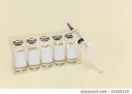 Syringe with a vaccine on a beige background Syringe with a vaccine on a beige background 81066339