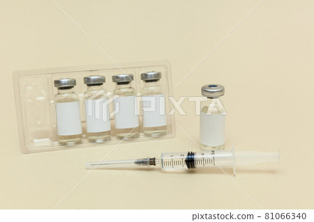 Syringe with a vaccine on a beige background 81066340