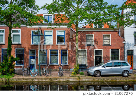 Cars on canal embankment in street of Delft. Delft, Netherlands 81067270