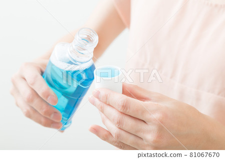 Woman with mouthwash 81067670